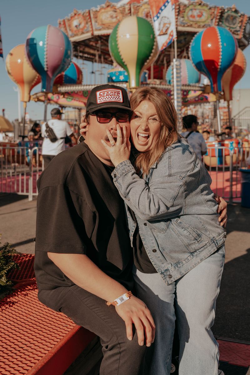 Ryan and Rachel laughing by the carousel and balloons