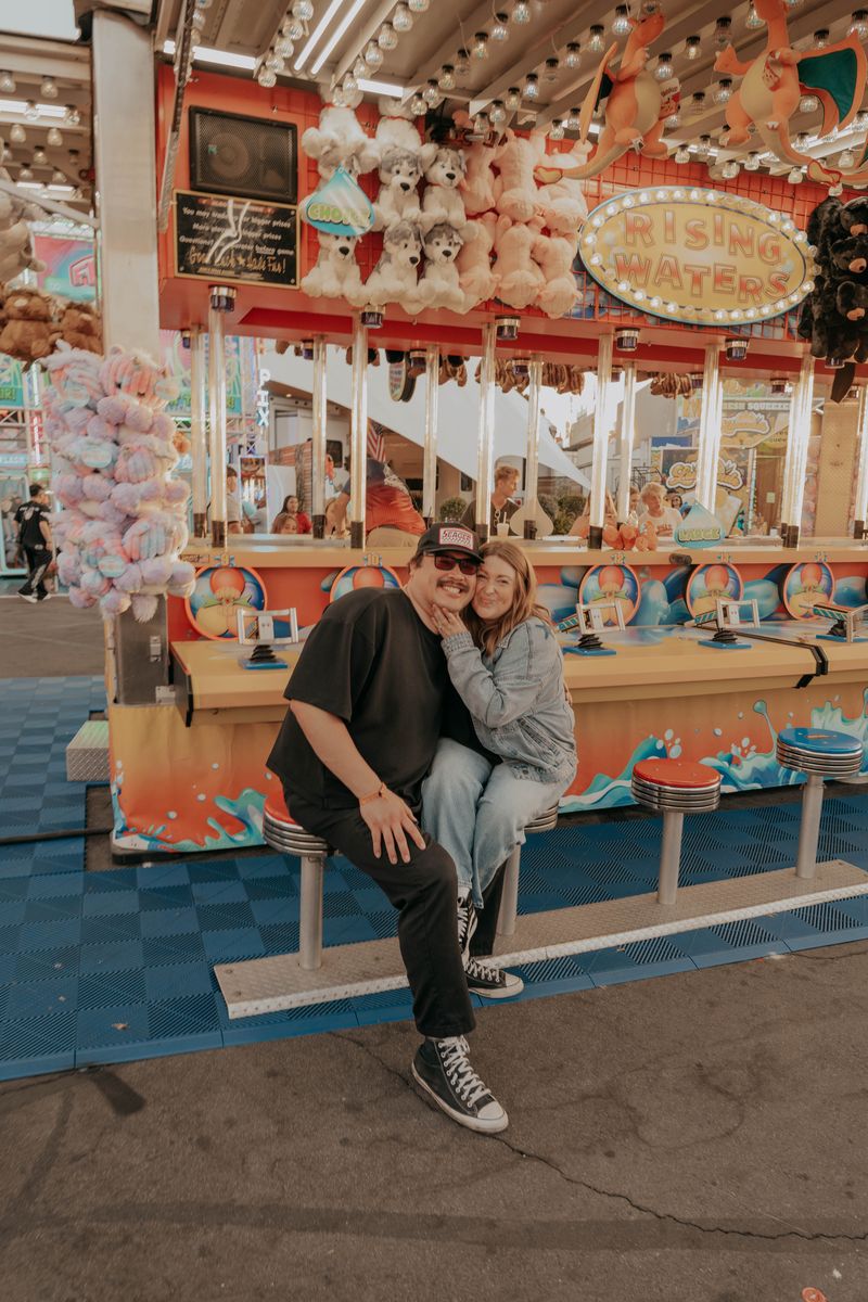 Ryan and Rachel sitting together on a bench by the carousel