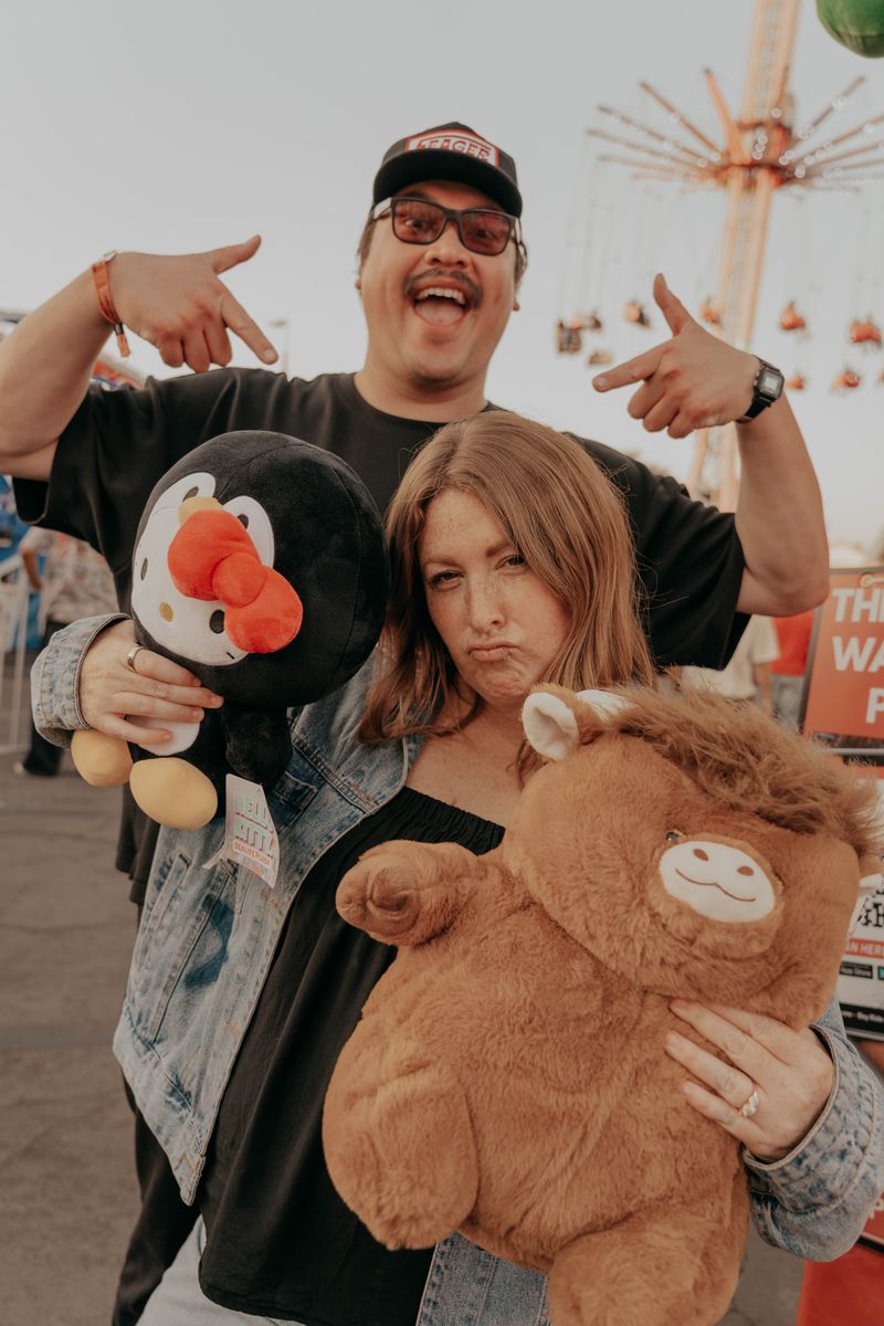 Ryan and Rachel holding carnival prizes on the midway
